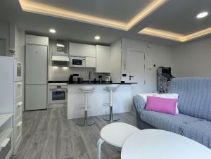 ein Wohnzimmer mit einem Sofa und einer Küche in der Unterkunft Apartamento Nuevo con patio, situado en el centro. in Avila