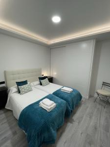 ein Schlafzimmer mit 2 Betten und Handtüchern darauf in der Unterkunft Apartamento Nuevo con patio, situado en el centro. in Avila