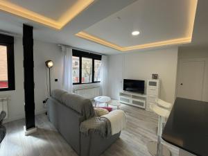 ein Wohnzimmer mit einem Sofa und einem Tisch in der Unterkunft Apartamento Nuevo con patio, situado en el centro. in Avila