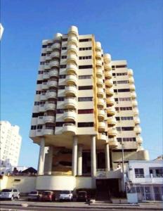 un edificio alto con coches estacionados frente a él en Apartamento mar, en Cartagena de Indias