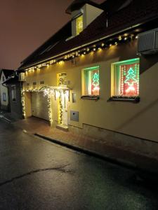 エゲルにあるSasvár Apartmanの夜の窓にクリスマスライトが灯る家