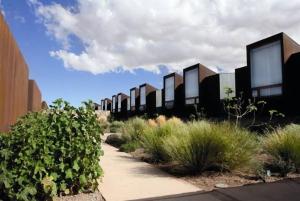 a row of buildings on a sidewalk with plants at Tierra Atacama Hotel & Spa in San Pedro de Atacama