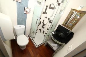 een badkamer met een toilet en een glazen douche bij Hôtel de France in Lens