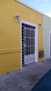 Casa Colonial Centro في ميريدا: مبنى اصفر عليه باب معدني