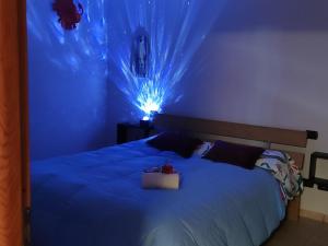 a blue bedroom with a bed with a light on it at New Home in Ferno