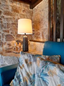 a lamp sitting on a table next to a blue couch at Fragas do Lobo - Casa da Azenha in Castelo Novo +32 photos