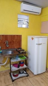 cocina con nevera blanca y fregadero en Quitinete Expominas Suite e Ar, en Belo Horizonte