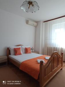 een slaapkamer met een bed met oranje lakens en een raam bij Apartman Anđelina Vrnjačka Banja in Vrnjačka Banja