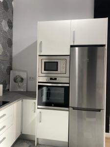 a kitchen with a stainless steel refrigerator and microwave at Loft Manuel de Falla in Maracena