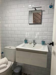 Baño blanco con lavabo y aseo en Loft Manuel de Falla, en Maracena