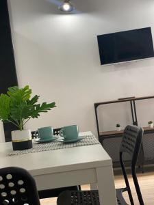 a table with two cups and a plant on it at Loft Manuel de Falla in Maracena