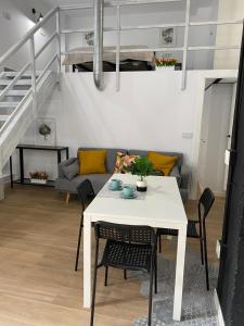 a living room with a white table and a couch at Loft Manuel de Falla in Maracena +7 photos