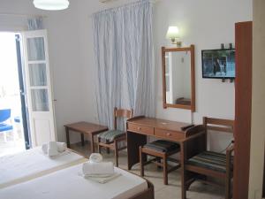 a hotel room with a bed and a desk and a mirror at Tatsis Apartments in Masouri