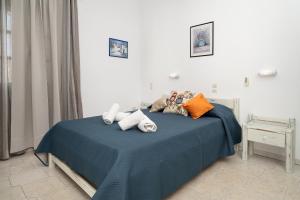 Un dormitorio con una cama azul con toallas. en Jodi's Pension, en Pitsidia