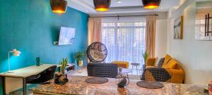 a living room with blue walls and a table at Modern luxury one bedroom furnished apartment in Kilimani, Nairobi, Kenya in Nairobi