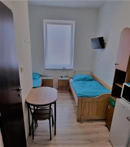 Habitación pequeña con mesa, cama y escritorio. en Ubytování Střekov Aréna, en Ústí nad Labem