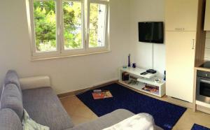 - un salon avec un canapé et une télévision dans l'établissement Apartments Ivanković, à Trogir