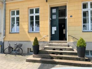 ein Gebäude mit einer schwarzen Tür und einem Fahrrad davor in der Unterkunft Das Ferienapartment Alexandrine direkt am Pfaffenteich mit eigenem Parkplatz in Schwerin