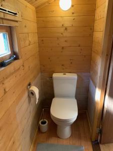 un bagno con servizi igienici in una baita di tronchi di The Bee - Trekkershuts & Apartment a Opperdoes