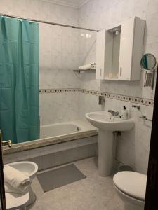 een badkamer met een wastafel, een toilet en een bad bij Apartamento Chamela in O Pindo