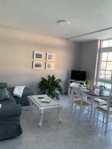 uma sala de estar com um sofá e uma mesa em Apartamento Chamela em O Pindo