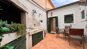 eine Terrasse mit einem Waschbecken und einem Tisch in einem Haus in der Unterkunft Guesthouse F in Split