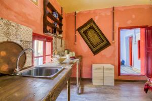 kuchnia z pomarańczowymi ścianami i zlewem w obiekcie Fatma Hanoum boutique hotel w mieście Rodos +37 zdjęć