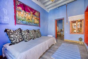 niebieski pokój z łóżkiem i obrazem na ścianie w obiekcie Fatma Hanoum boutique hotel w mieście Rodos