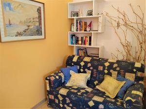 een woonkamer met een bank en een boekenplank bij Le Betulle in Vezzano