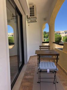Habitación con mesa, bancos y ventanas. en Quinta Nova 103, en Alvor