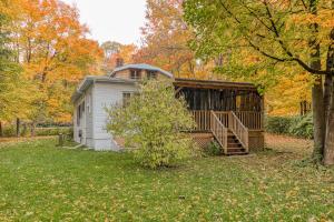 Saint-Laurent-de-l'ile d'Orleans的住宿－MOWEB - CHALET BORD DE L'EAU AVEC PLAGE iLE ORLEANS，院子中间的小房子