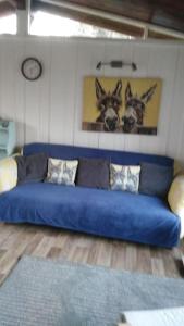 a blue couch in a living room with a clock at No 27 A dog friendly rural coastal chalet in Seaton