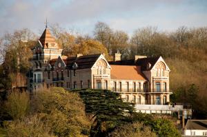 a large house on top of a hill with trees at The Petersham in Richmond upon Thames