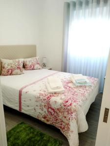 Un dormitorio con una cama con dos libros. en Sol e praia, en Nazaré