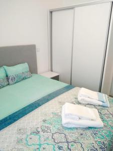 1 dormitorio con 1 cama con toallas en Sol e praia, en Nazaré