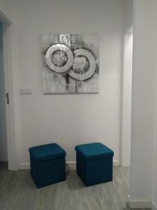 two blue stools in front of a painting on a wall at Sol e praia in Nazaré