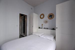 a white bedroom with a white bed and two mirrors at Studio cozy proche Intra-Muros in Saint Malo