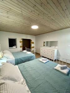 a bedroom with two beds and a television in it at Villa Eftychia Serene Getaway with Hot Tub in a Quiet Location in Kissamos