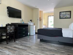 sypialnia z łóżkiem, biurkiem i telewizorem w obiekcie Yosemite Sierra Inn w mieście Oakhurst