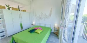 a bedroom with a green bed and a window at Fior di Sicilia Loft in Marzamemi