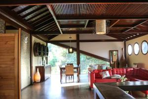 a living room with a red couch and a table at Flamboyant Residence in Fernando de Noronha