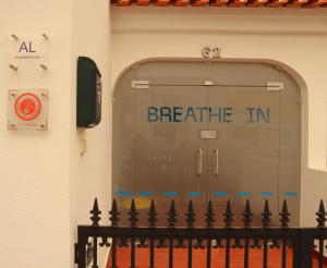 a garage door with the words breathe in written on it at Breathe In in Zambujeira do Mar