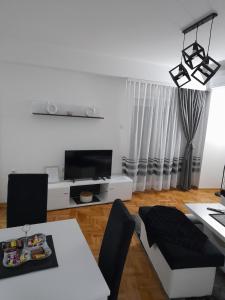 a white living room with a white table and chairs at Holiday apartments in Niš