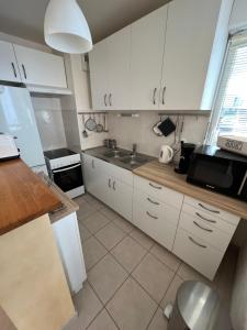 a kitchen with white cabinets and a sink at L'escapade in Chantepie