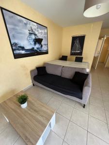 a bedroom with a bed and a couch and a painting at L'escapade in Chantepie