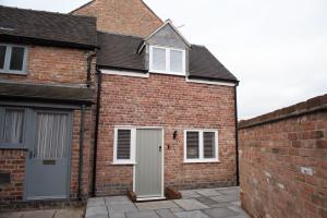 una casa de ladrillo con una puerta blanca y un garaje en Modern finish to a historic brewers house, Derby en Derby