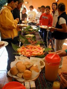 un gruppo di persone che si trovano intorno a un tavolo con cibo di Reserva Natural Atitlan a Panajachel