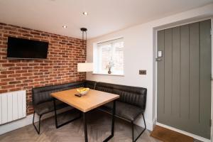 a dining room with a table and chairs and a brick wall at Modern finish to a historic brewers house, Derby in Derby