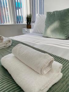 zwei weiße Handtücher liegen auf einem Bett in der Unterkunft Rodney Parade Mews in Newport