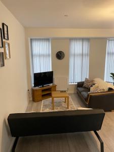 a living room with a couch and a tv at Rodney Parade Mews in Newport